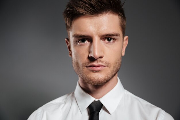 Handsome elegant man in shirt and tie looking at camera