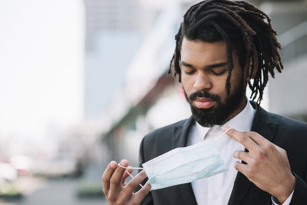 Handsome employee holding medical mask