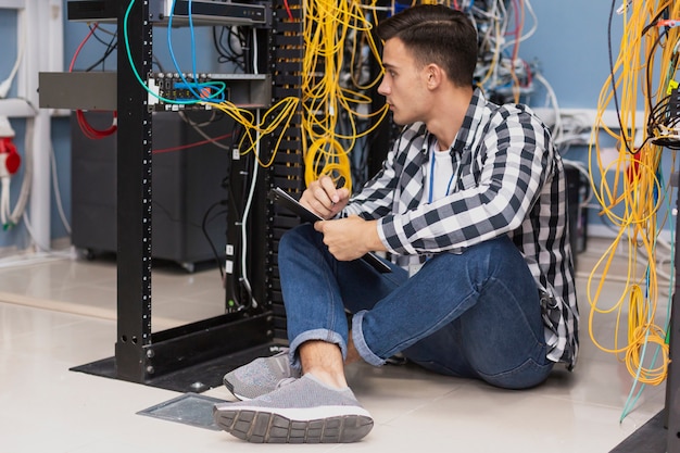 Handsome engineer working in server room