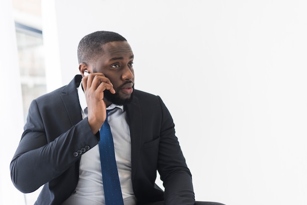 Красивый этнический бизнесмен говорить по телефону