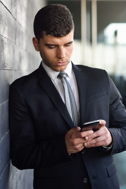 Handsome executive sending a text message