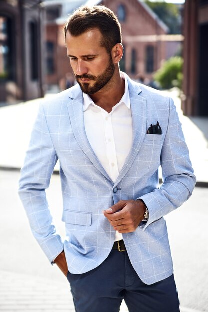 красивый модный бизнесмен модель в элегантном синем костюме позирует на улице