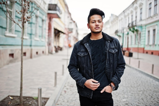 Handsome and fashionable indian man in black jeans jacket posed outdoor