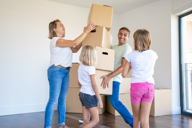 Free photo handsome father holding stack of boxes and smiling