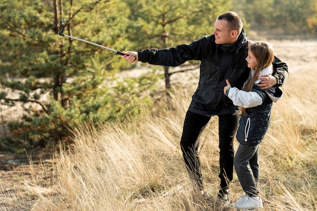 Foto gratuita padre bello che prende un selfie con la figlia