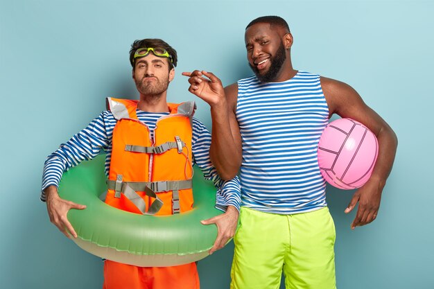 Handsome friends posing with beach items