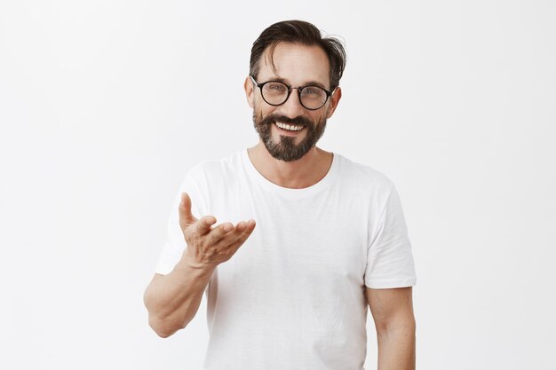 Handsome grateful bearded mature man with glasses posing