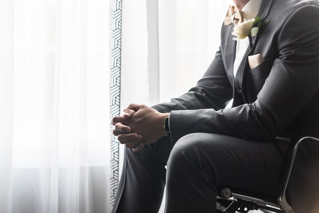 Handsome groom in a black suit praying before the wedding ceremony