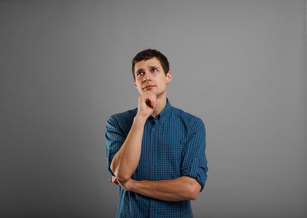 Free photo handsome guy in blue shirt thinking