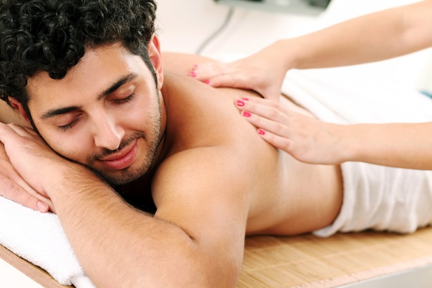 Free photo handsome guy enjoying massage therapy