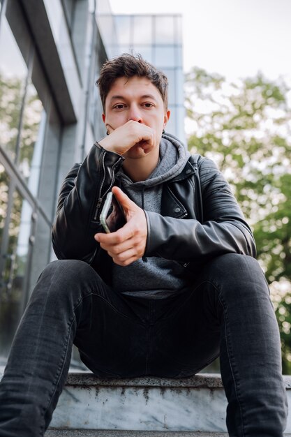 Handsome Guy is sitting on the stairs. Outdoor