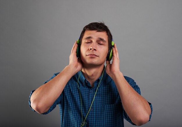 Handsome guy listens to music with closed eyes