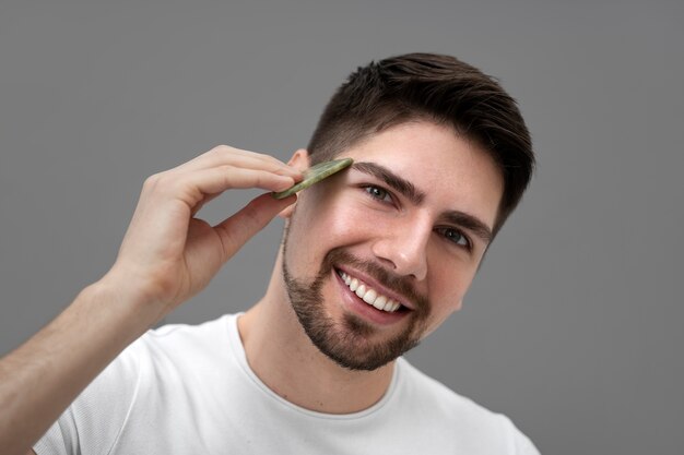 Handsome guy massaging his face