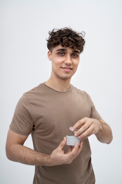 Free photo handsome guy opening lotion jar