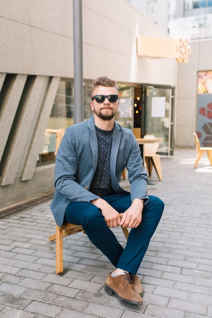 Handsome guy sitting on chair outdoors