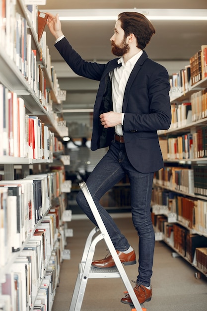 Foto gratuita bel ragazzo studia presso la biblioteca