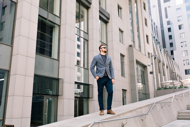 Handsome guy in sunglasses is standing at the street