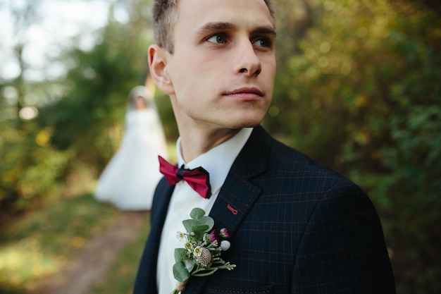 Free photo handsome guy in tuxedo looking away standing