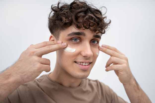 Foto gratuita ragazzo bello con la lozione sul viso