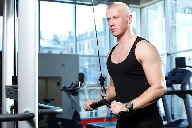 Handsome guy working out in a gym 