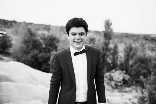 Handsome and happy groom in a suit walking outdoors