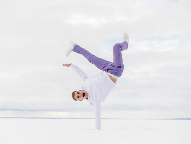 雪の中で外のハンサムなヒップホップダンサー