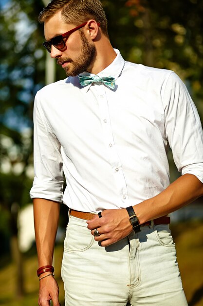 Handsome hipster model man in stylish summer clothes posing in sunglasses