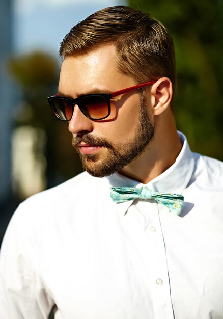 Красивый битник модель мужчина в стильной летней одежде позирует в солнцезащитные очки