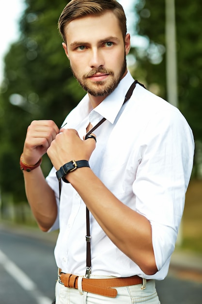 Handsome hipster model man in stylish summer clothes posing