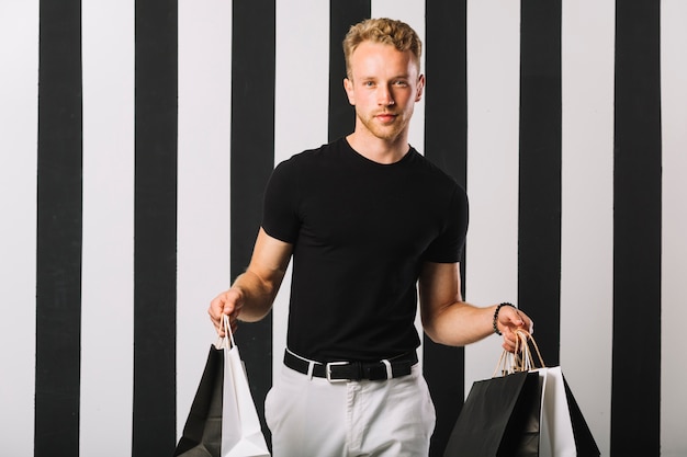 Handsome male holding shopping bags
