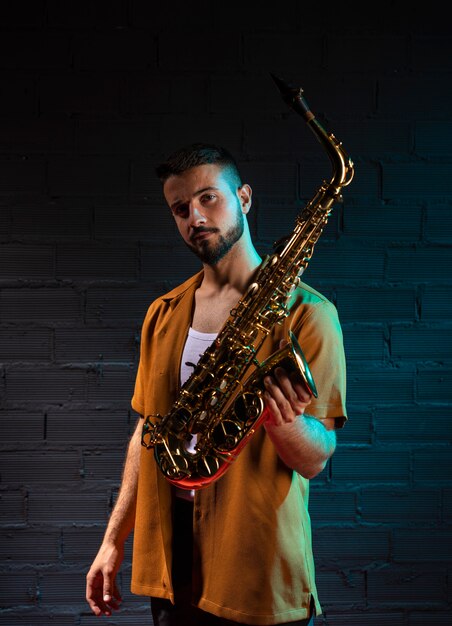 Handsome male musician holding saxophone