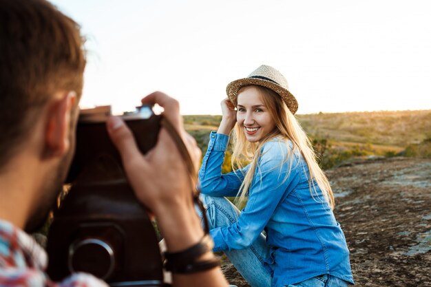 Handsome male photographer taking picture of his womanfriend