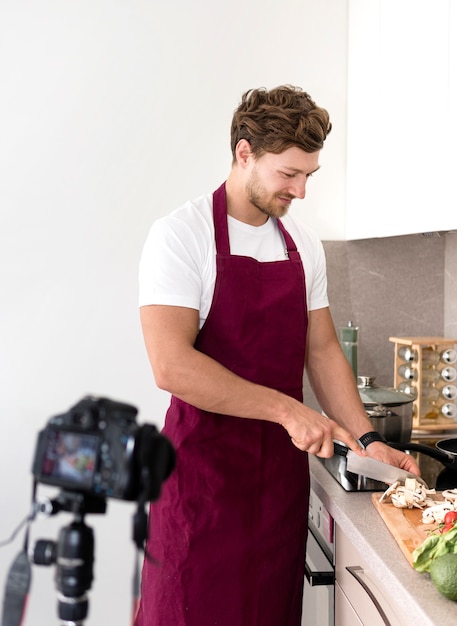 Free photo handsome male recording while cooking at home