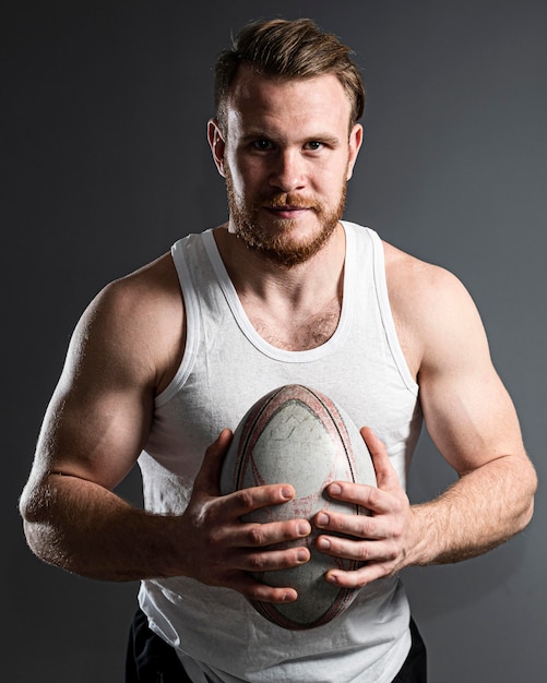 Bel giocatore di rugby maschio tenendo palla