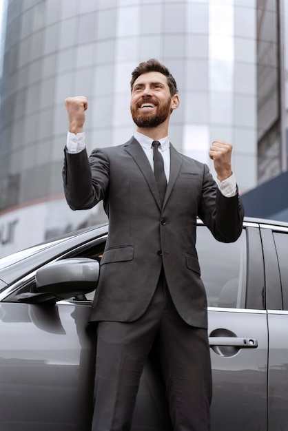 Free photo handsome male taxi driving standing next to his cab