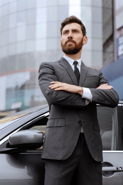 Handsome male taxi driving standing next to his cab