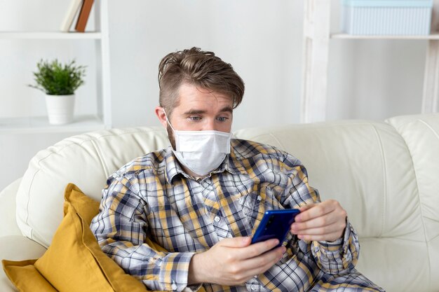 Handsome male with face mask holding phone