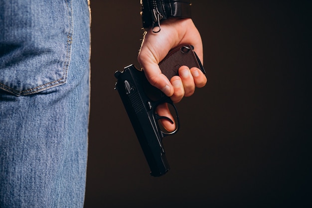 Handsome man actor posing in studio with weapon