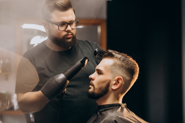 Handsome man at a barber shop styling hair