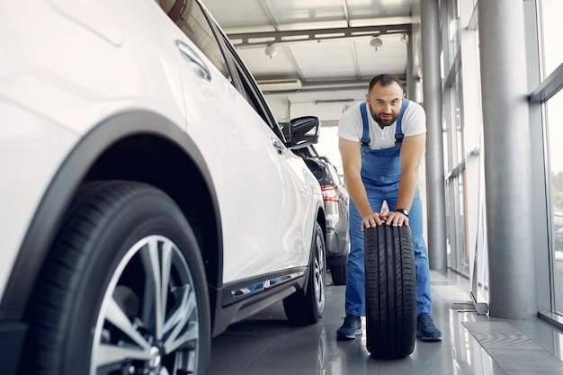 Free photo handsome man in a blue uniform checks the car