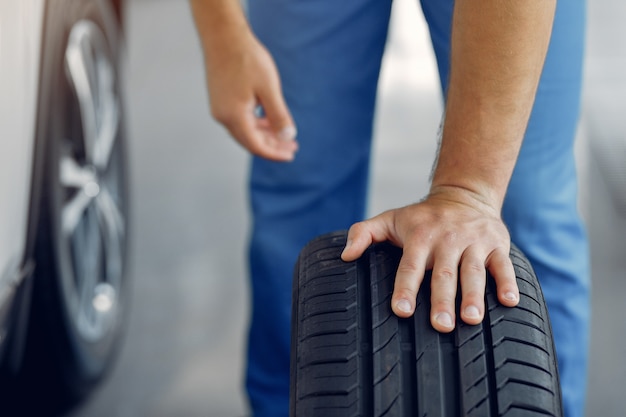 Free photo handsome man in a blue uniform checks the car