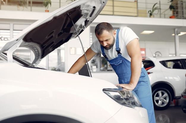 Handsome man in a blue uniform checks the car