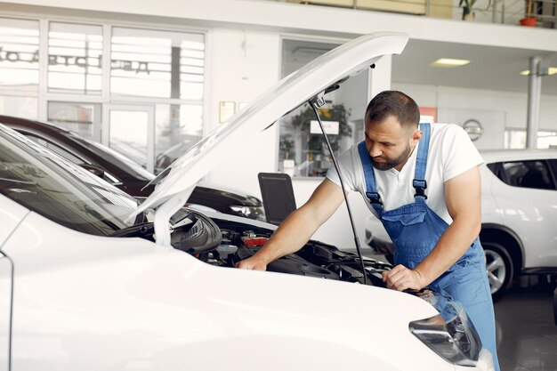 Handsome man in a blue uniform checks the car