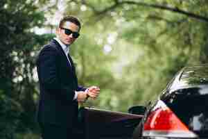 Free photo handsome man by car