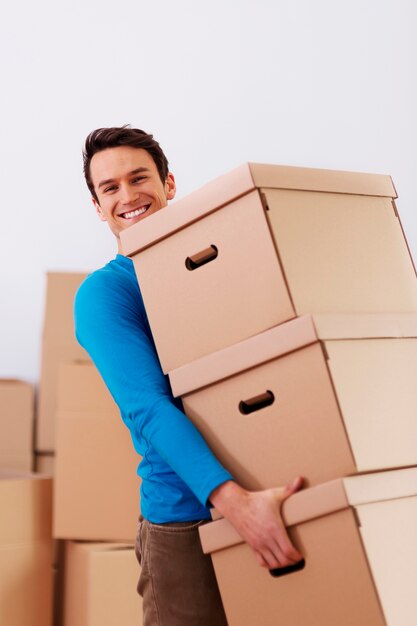 Handsome man carrying stack of boxes