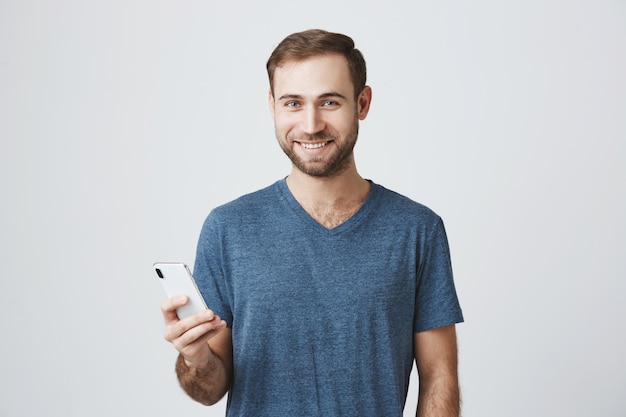 Handsome man in casual t-shirt using mobile phone