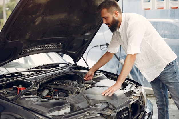 Handsome man checks the engine in his car