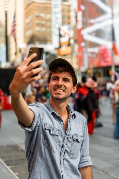 Uomo bello in città che prende selfie