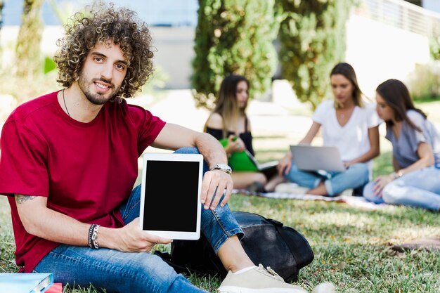 Handsome man demonstrating tablet to camera