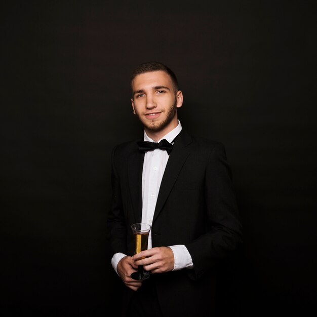 Handsome man in dinner jacket with glass of drink